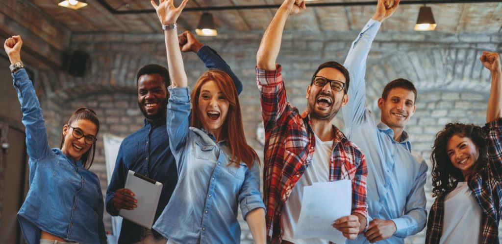 Pessoas felizes, levantando o braços para cima 